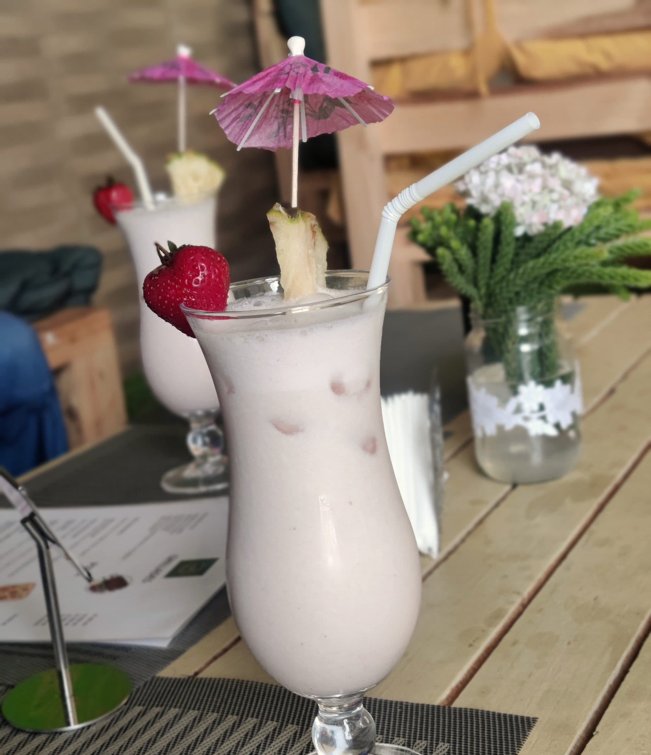 Cocktails crémeux et ombrelle en papier sur la terrasse