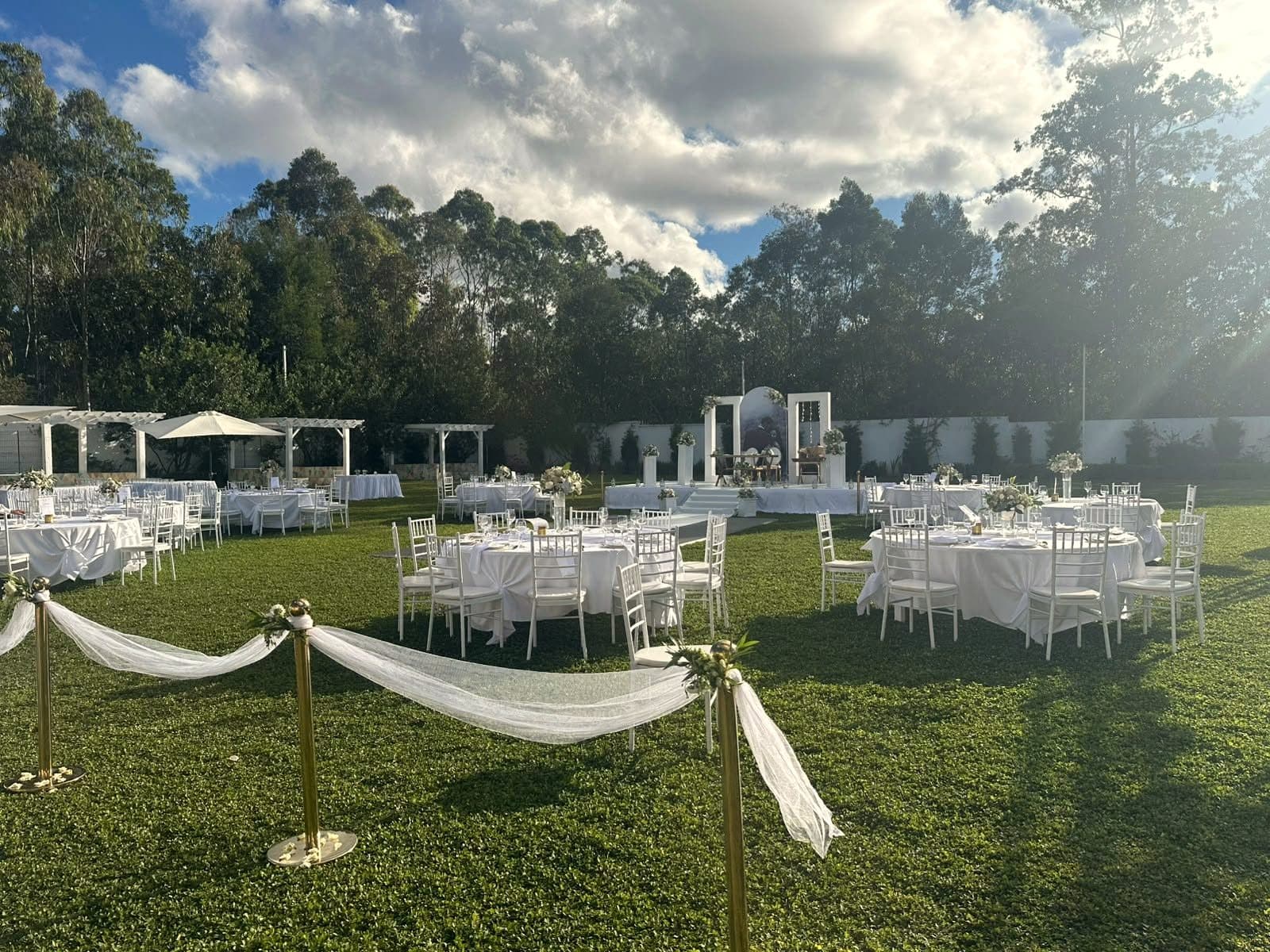 Le grand parc du domaine, des tables dressées sur la pelouse devant la forêt d'eucalyptus