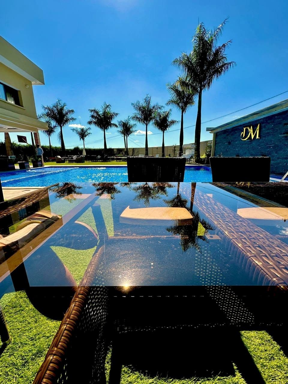 Les palmiers et le ciel se reflètent dans la piscine du domaine