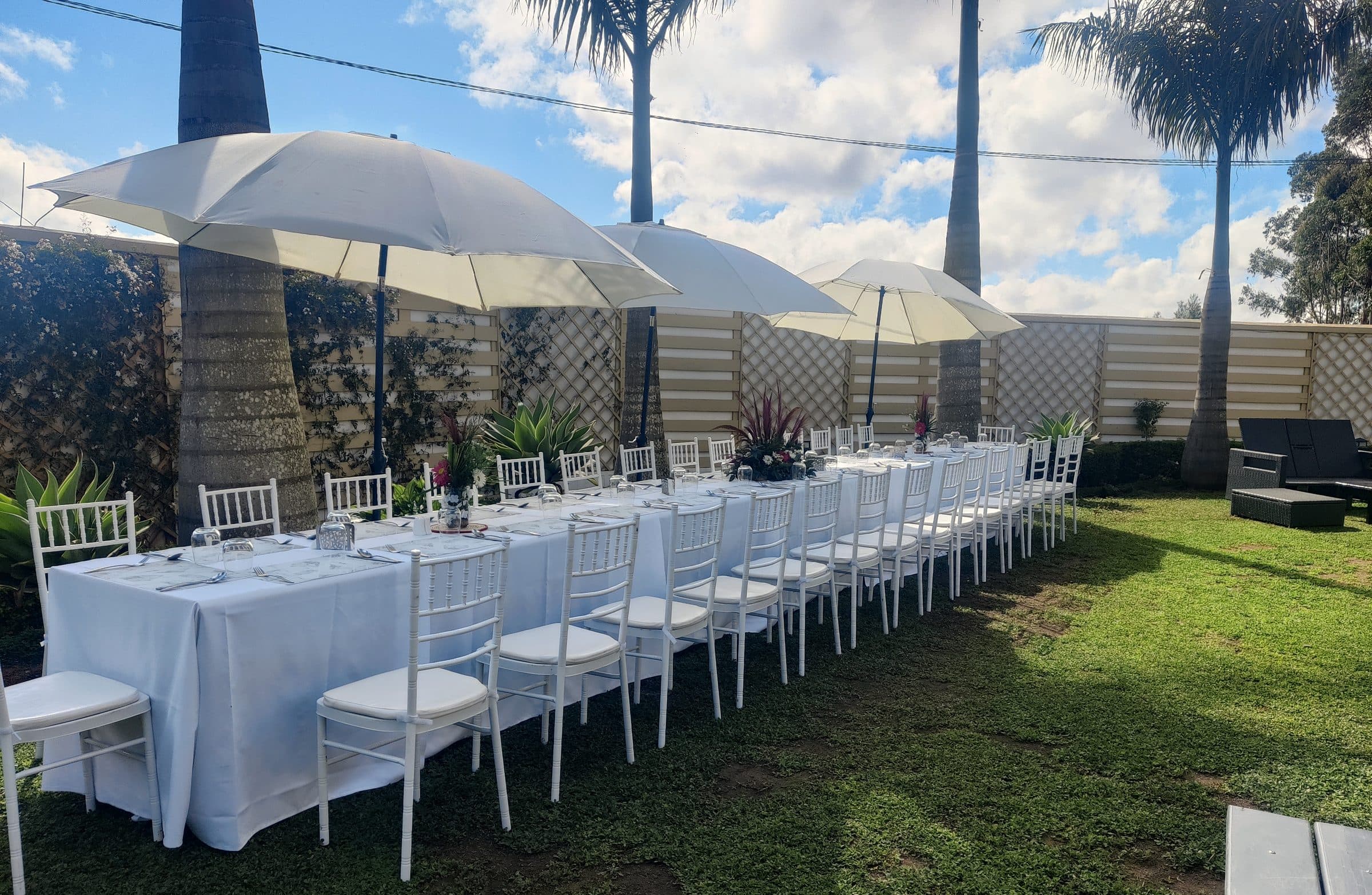 Grandes tablées sous les parasols dans le jardin
